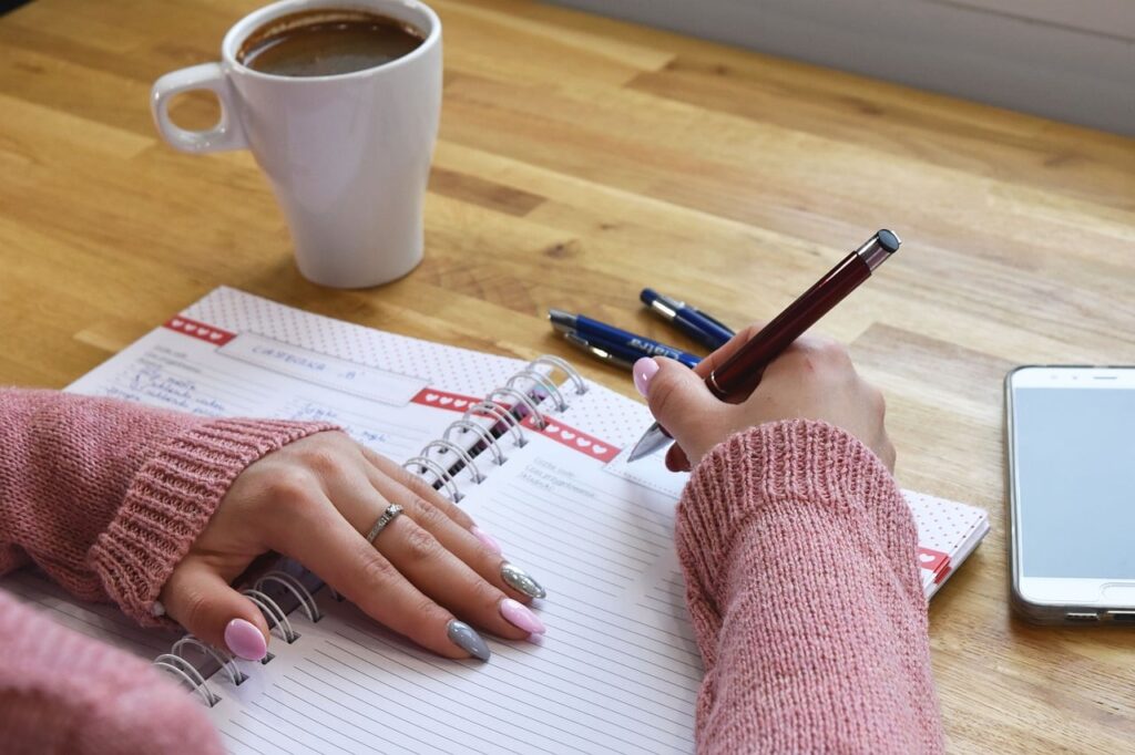 writing, notebook, planning, handwritten, coffee, pen, work, table, mobile phone, hand, office, study, writing pad, manicure, relaxation, page, wooden table, beautiful ring, calm, organizer, ai generated